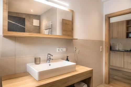 a bathroom with a white sink and a mirror at Peterlehen Appartements in Altenmarkt im Pongau