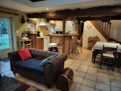 un salon avec un canapé et une cuisine dans l'établissement Le p'tit hameau de Sey, à Quettehou