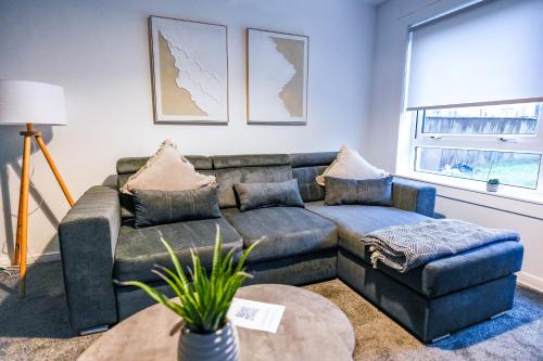 een woonkamer met een bank en een tafel bij Sedgebank House in Uphall