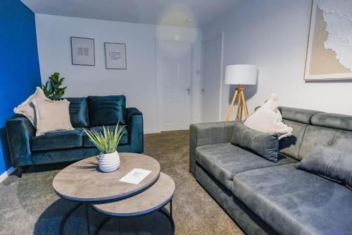 een woonkamer met twee banken en een tafel bij Sedgebank House in Uphall