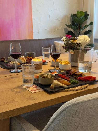 un tavolo in legno con bicchieri da vino e cibo sopra di Private Longevity Retreat a Weinstadt