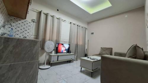 un soggiorno con un divano e una TV di Bienvenue chez vous a Libreville