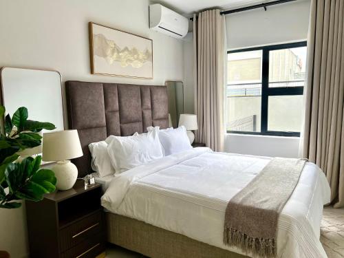 a bedroom with a large bed and a window at Cozy Habitat in Gaborone