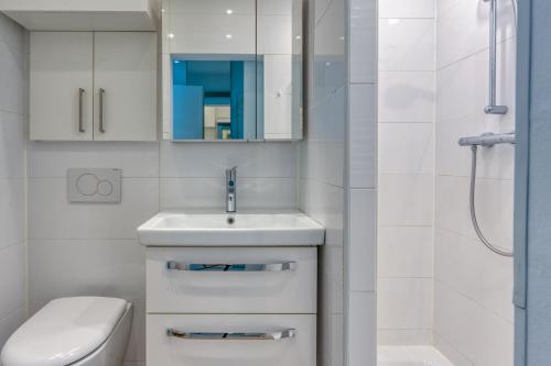 a white bathroom with a sink and a toilet at Alte Teestube 55 in Norderney