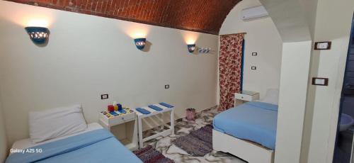 阿斯旺malindy KA nubian houseماليندى كا的一间有两张床和一张桌子的小卧室