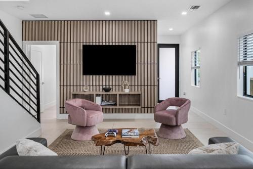 a living room with two chairs and a television at Luxury Home with Inter Miami Theme in Miami