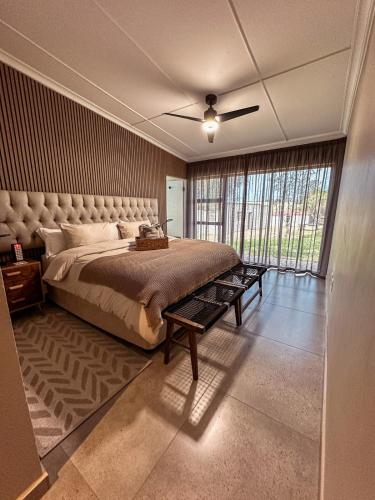 a bedroom with a large bed and a large window at Forestview Luxury Farm Stay in Bellcrest