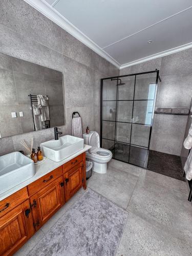 a bathroom with two sinks and a shower and a toilet at Forestview Luxury Farm Stay in Bellcrest