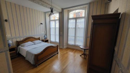 une chambre avec un lit et deux fenêtres dans l'établissement Les Gîtes Chez Léo, à Bar-sur-Aube