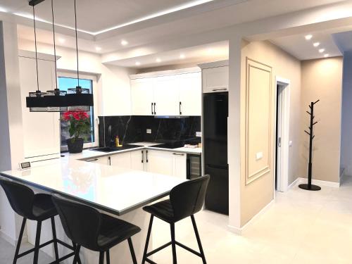 Una cocina con refrigerador negro y gabinetes blancos. en David’s place, en Floreşti