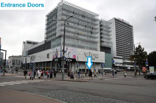 a group of people crossing a street in front of a building at Viru Väljak Homes in Tallinn