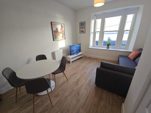 a living room with a table and a couch at 2 Bed Apartment with Harbour Views Apt 2 in Cobh