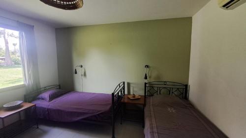 a bedroom with two beds and a table and a window at 20 ' keur in Boukot Ouolof