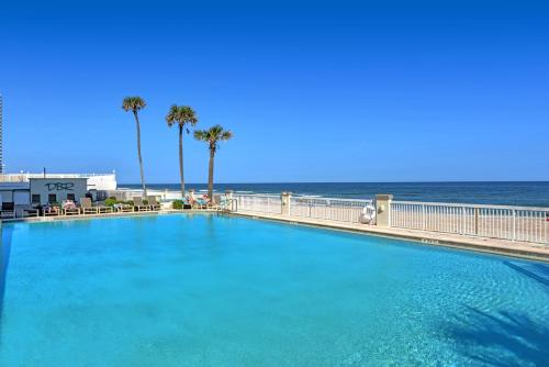 a large swimming pool with the ocean in the background at Daytona Beach Resort Condos in Daytona Beach