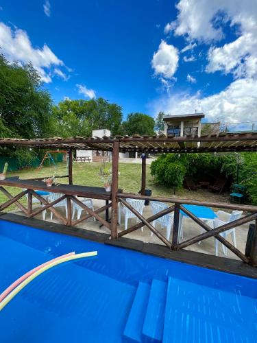 un ponte di legno sopra una piscina con una casa sullo sfondo di Cabañas Canluma a Villa Giardino