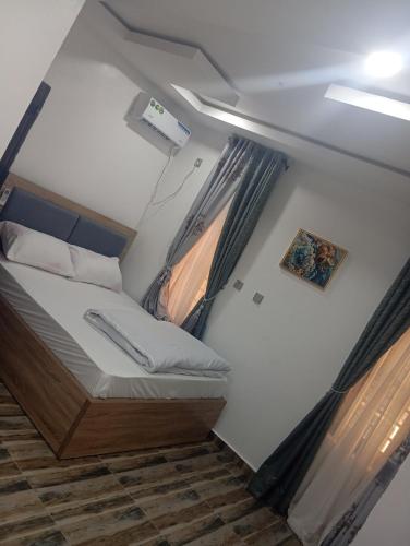 a small room with a bed and a window at Luxury 3 Bedroom Duplex with Mini Swimming Pool in Enugu