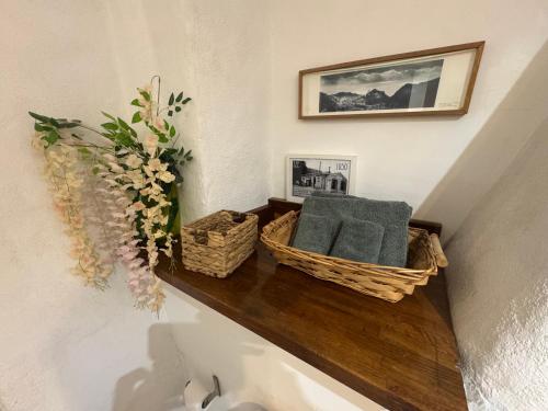 uno scaffale con due cestini e un vaso di fiori di Auberge de la Croix du Pape a Èze