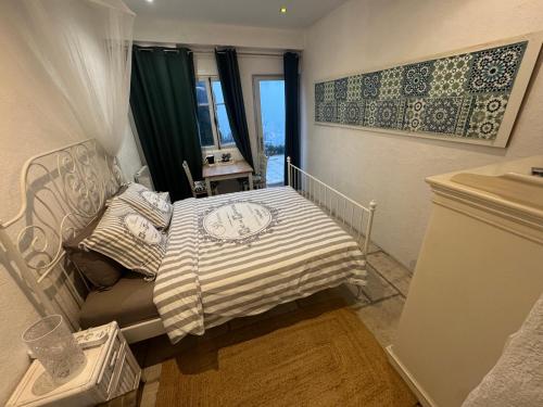 una piccola camera da letto con un letto e una finestra di Auberge de la Croix du Pape a Èze