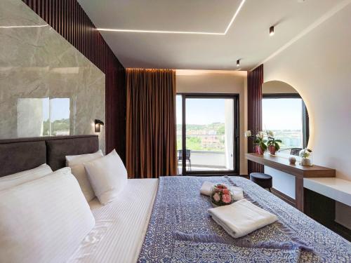 a hotel room with a bed and a large window at Hotel Lajka Luxury in Ulcinj