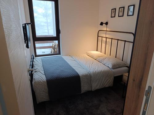 een kleine slaapkamer met een bed en een raam bij Pino Silvestre Divčibare in Divčibare