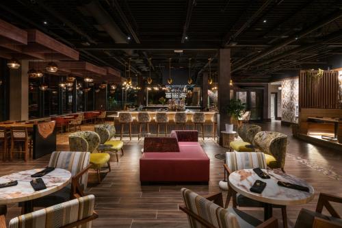 a restaurant with tables and chairs and a bar at Hotel Indigo Gatlinburg Downtown by IHG in Gatlinburg
