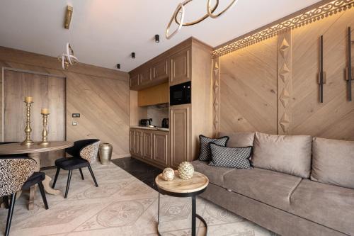 uma sala de estar com um sofá e uma mesa em Willa Tatrzańska Luxury Apartments & Spa em Murzasichle