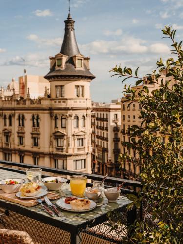 ein Tisch mit Tellern mit Essen und Getränken auf einem Balkon in der Unterkunft Hotel Casa Luz in Barcelona