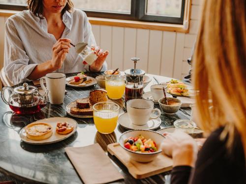 Eine Frau, die an einem Tisch mit Frühstückslebensmittel sitzt. in der Unterkunft Hotel Casa Luz in Barcelona