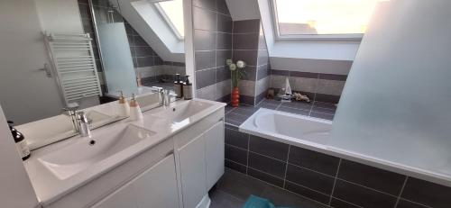 een badkamer met twee wastafels en een bad en een raam bij Maison moderne à Baden in Baden
