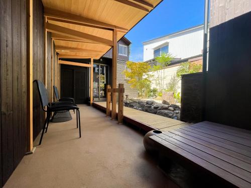 un porche de maison avec un banc en bois dans l'établissement Kokoro no Yado, à Nara