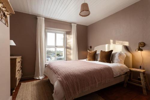 een slaapkamer met een groot bed en een raam bij Traditional Cornish Cottage & Garden Redruth in Redruth