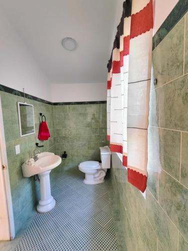 a bathroom with a toilet and a sink at Casa Los Mangales in Brisas de Zicatela