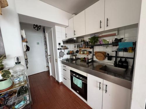 een keuken met witte kasten en een zwart aanrechtblad bij Departamento Concon Valparaíso in Concón