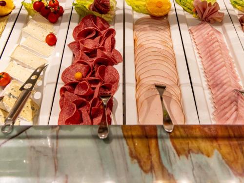 een vitrine met vlees en vleeswaren op vorken bij Mercure Hotel Frankfurt Airport Langen in Langen