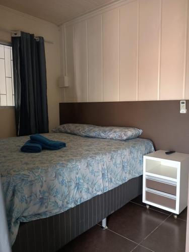 a small bedroom with a bed and a night stand at Casa do refúgio melhor para suas férias in Palhoça