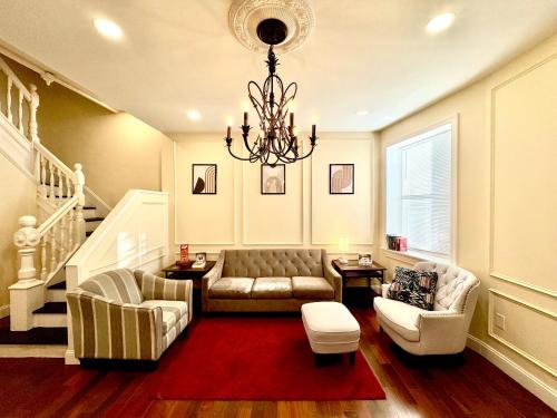 a living room with a couch and a chandelier at Historic Madison Ave in Baltimore