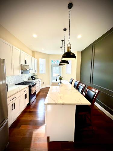 a kitchen with a large white island with a black refrigerator at Historic Madison Ave in Baltimore