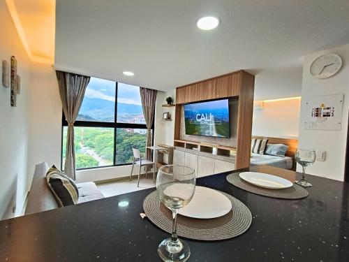 een eetkamer met een tafel met twee wijnglazen bij Cali - Apartaestudios Edificio Miro Living Guadalupe in Cali
