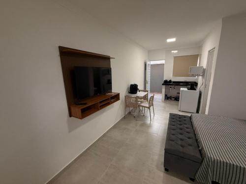 een woonkamer met een televisie aan de muur bij Flats Privativos MaragoJulios in Maragogi