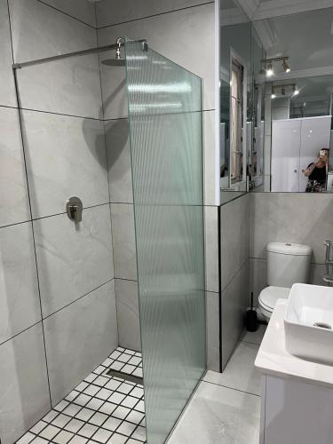 a glass shower in a bathroom with a toilet at Malibu Dream in Gqeberha