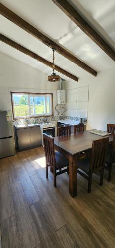 una cucina con un tavolo e sedie in una stanza di Cabañas Puelche a Liquiñe