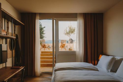 ein Schlafzimmer mit Bett und Blick auf einen Balkon in der Unterkunft Hotel Casa Luz in Barcelona