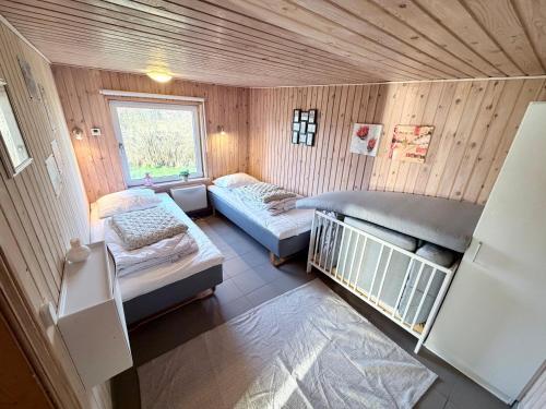 a small room with two beds and a window at Amtoft Vig Kitespot in Vesløs