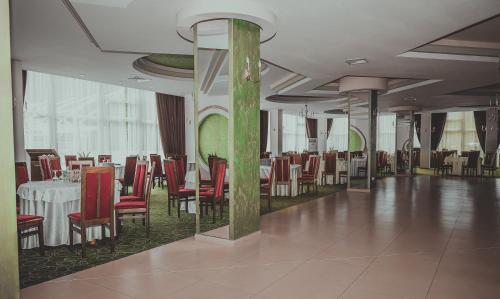 a dining room with a table and red chairs at Bacolux Diana, Herculane in Băile Herculane