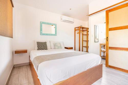 a bedroom with a large white bed in a room at La Buena vida Cabina 1 in Playa Grande