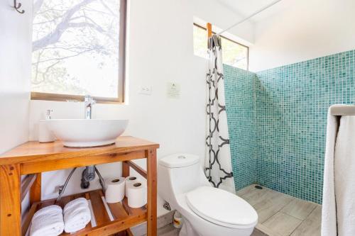 a bathroom with a sink and a toilet and a shower at La Buena vida Cabina 1 in Playa Grande
