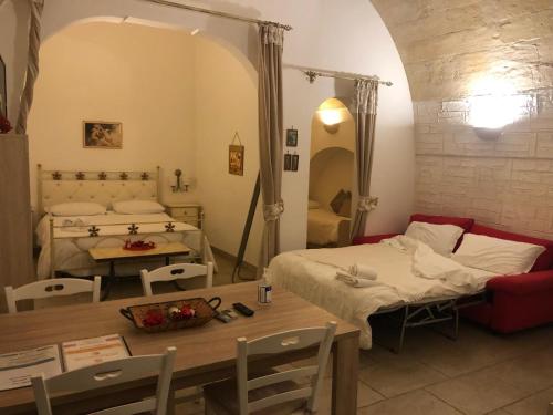 a living room with a bed and a table and a room with a dining room at Suite San Francesco in Grottaglie