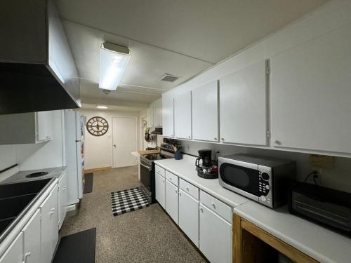 een keuken met witte kasten en een magnetron bij The Holler in Andrews