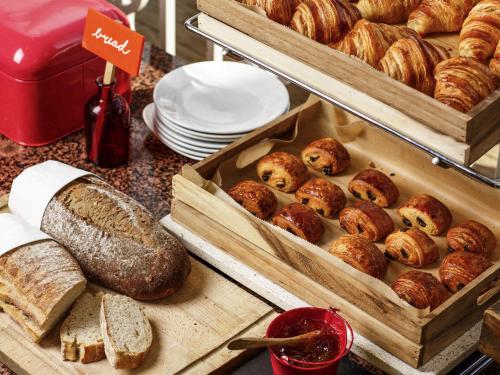 un tavolo ricoperto di vassoi di pane e prodotti da forno di Mercure Nottingham Sherwood a Nottingham