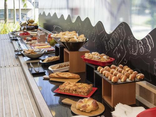 a buffet line with many different types of bread and pastries at ibis Itatiba in Itatiba